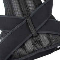 Close-up of a black and gray back brace with mesh design on a white background